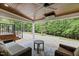 Covered outdoor patio features a wood ceiling, ceiling fan, stone flooring, and a view of the backyard at 1501 Chatsworth Ln, Raleigh, NC 27614