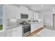 Modern kitchen featuring white cabinetry, granite countertops, and stainless steel appliances at 151 Bridge St, Hillsborough, NC 27278