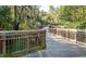 Scenic wooden walking trail through a lush park with signs pointing towards River Park and Gold Park at 151 Bridge St, Hillsborough, NC 27278
