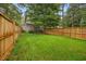 Fenced backyard featuring a lush green lawn with mature trees at 151 Lake Pine Dr, Cary, NC 27511