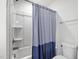 Clean bathroom includes a shower/tub with a blue shower curtain and a toilet at 1728 Shady Oaks Dr, Wendell, NC 27591