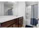 Bright bathroom with a wooden vanity, large mirror and shower with curtain rod at 1728 Shady Oaks Dr, Wendell, NC 27591