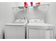Bright laundry room with white washer and dryer, overhead shelving and white walls at 1728 Shady Oaks Dr, Wendell, NC 27591