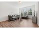 Comfortable living room featuring three large windows, two couches, and hard surface floors at 1728 Shady Oaks Dr, Wendell, NC 27591