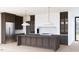 Gourmet kitchen boasts custom cabinets, large island, stainless appliances, designer lighting, and a marble backsplash at 1808 Stream Manor Ct, Wake Forest, NC 27587
