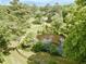 Areal view of secluded lot featuring a pond surrounded by a wooded area with mature trees at 183 Birnamwood Dr, Chapel Hill, NC 27516