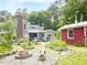 Landscaped backyard with a fire pit, raised garden beds, and access to a red shed at 183 Birnamwood Dr, Chapel Hill, NC 27516
