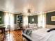 Comfortable bedroom featuring wooden floors, large windows, dark green walls, and a decorative bookshelf at 183 Birnamwood Dr, Chapel Hill, NC 27516