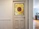 Interior door boasts stained glass paneling and white trim, leading to a living space with wooden floors at 183 Birnamwood Dr, Chapel Hill, NC 27516