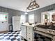 Cozy kitchen with black and white checkered floors, white appliances, and unique, colorful wallpaper at 183 Birnamwood Dr, Chapel Hill, NC 27516