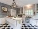 Classic kitchen featuring checkered flooring, white cabinetry, and a functional center island with cooktop at 183 Birnamwood Dr, Chapel Hill, NC 27516