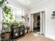 Cozy sunroom filled with natural light and plants, featuring a cabinet and view to another room at 183 Birnamwood Dr, Chapel Hill, NC 27516