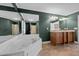 A luxurious bathroom featuring a large soaking tub, dark green walls, and a double sink vanity at 1852 Gwyn Rd, Burlington, NC 27217