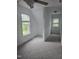 Bright bedroom with neutral carpet and two large windows and a hallway that connects to another room at 1852 Gwyn Rd, Burlington, NC 27217