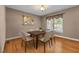 Cozy dining room featuring hardwood floors, a modern table, and natural light from the window at 1852 Gwyn Rd, Burlington, NC 27217