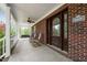 Inviting front porch with swing and rocking chairs, offering a relaxing outdoor space and a charming brick exterior at 1852 Gwyn Rd, Burlington, NC 27217