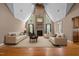 Staged living room featuring high ceilings, a stone fireplace, and abundant natural light from large windows at 1852 Gwyn Rd, Burlington, NC 27217