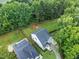Aerial view showcasing the backyard with a playset, surrounded by mature trees and a well-maintained lawn at 20 Scotland Dr, Youngsville, NC 27596