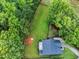 Aerial view highlighting the backyard with a playset, surrounded by mature trees and a well-maintained lawn at 20 Scotland Dr, Youngsville, NC 27596