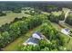 Aerial shot featuring a home surrounded by mature trees and farmland, highlighting the property's serene setting at 20 Scotland Dr, Youngsville, NC 27596