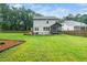 Spacious backyard features a patio, lush lawn, mature trees and manicured landscaping at 20 Scotland Dr, Youngsville, NC 27596