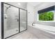 Beautiful bathroom features a glass enclosed shower and a soaking tub with a view at 20 Scotland Dr, Youngsville, NC 27596