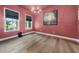 Salmon colored dining room featuring hardwood floors, a modern chandelier, and large window views of the exterior at 20 Scotland Dr, Youngsville, NC 27596