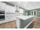 Open kitchen featuring white cabinets, stainless steel appliances, and a large center island at 20 Scotland Dr, Youngsville, NC 27596