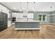 Open kitchen featuring white cabinets, stainless steel appliances, and a large center island at 20 Scotland Dr, Youngsville, NC 27596