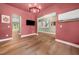 Salmon living room leads to other rooms featuring hardwood floors, artwork, and a ceiling chandelier at 20 Scotland Dr, Youngsville, NC 27596