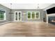 Spacious living room featuring hardwood floors, a fireplace, and large windows offering backyard views at 20 Scotland Dr, Youngsville, NC 27596