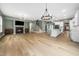Spacious open-concept living area with a fireplace, staircase, hardwood floors, and connected to the kitchen at 20 Scotland Dr, Youngsville, NC 27596
