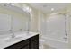 Bright bathroom boasts a double sink vanity and a combination shower and tub unit at 2018 Morehead Hill Ct, Durham, NC 27703