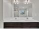 Bathroom featuring double vanity with dark cabinets and a large mirror, reflecting tub and shower at 2018 Morehead Hill Ct, Durham, NC 27703