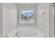 Bright bathroom with white garden tub next to window, with chrome faucet and fixtures at 2018 Morehead Hill Ct, Durham, NC 27703
