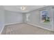 Comfortable bedroom with neutral walls and carpet features two windows offering ample natural light at 2018 Morehead Hill Ct, Durham, NC 27703