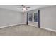 Neutral bedroom featuring a ceiling fan and window with gray curtains and neutral carpet at 2018 Morehead Hill Ct, Durham, NC 27703