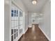 Hallway with hardwood floors and glass-paneled doors, leading to other rooms in the house at 2018 Morehead Hill Ct, Durham, NC 27703