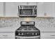 Modern stainless steel cooktop with oven and microwave above at 2018 Morehead Hill Ct, Durham, NC 27703