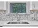 Kitchen sink with stainless steel faucet and mosaic backsplash with a window view at 2018 Morehead Hill Ct, Durham, NC 27703