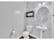 Small powder room with pedestal sink, toilet, and decorative wall shelf at 2018 Morehead Hill Ct, Durham, NC 27703