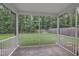 Screened porch overlooking a green lawn with a wooded backdrop and a swing set at 2018 Morehead Hill Ct, Durham, NC 27703