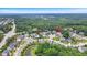 Wide aerial shot of residential neighborhood surrounded by lush greenery, a pond and winding roads at 208 Cecelia Ct, Cary, NC 27519