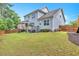 The manicured backyard features a stone patio, a covered porch, green grass, and a charming wooden fence at 208 Cecelia Ct, Cary, NC 27519