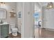 Stylish half-bathroom featuring modern sink and wooden shelves, with view through to the living area at 208 Cecelia Ct, Cary, NC 27519