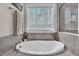 Soaking tub with tile surround, a window view and a shower enclosure that creates a luxurious bath at 208 Cecelia Ct, Cary, NC 27519