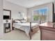 A cozy bedroom with neutral colors, hardwood floors, and a large window for natural light at 208 Cecelia Ct, Cary, NC 27519
