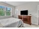 Bedroom with neutral walls and carpet, a large window, a TV and wooden furniture at 208 Cecelia Ct, Cary, NC 27519