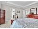 Inviting bedroom with patterned bedding, tray ceiling and views to an ensuite bath and dressing area at 208 Cecelia Ct, Cary, NC 27519