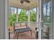 Relaxing covered porch featuring wood flooring, a ceiling fan, and comfortable seating overlooking a lush, green landscape at 208 Cecelia Ct, Cary, NC 27519